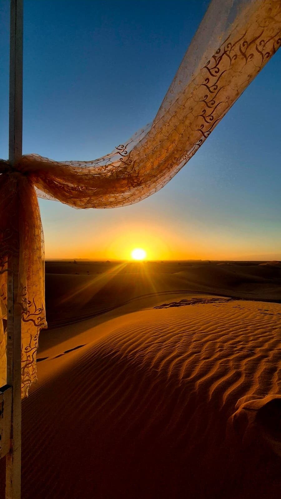 The sun rising over the sand dunes, seen from a tent