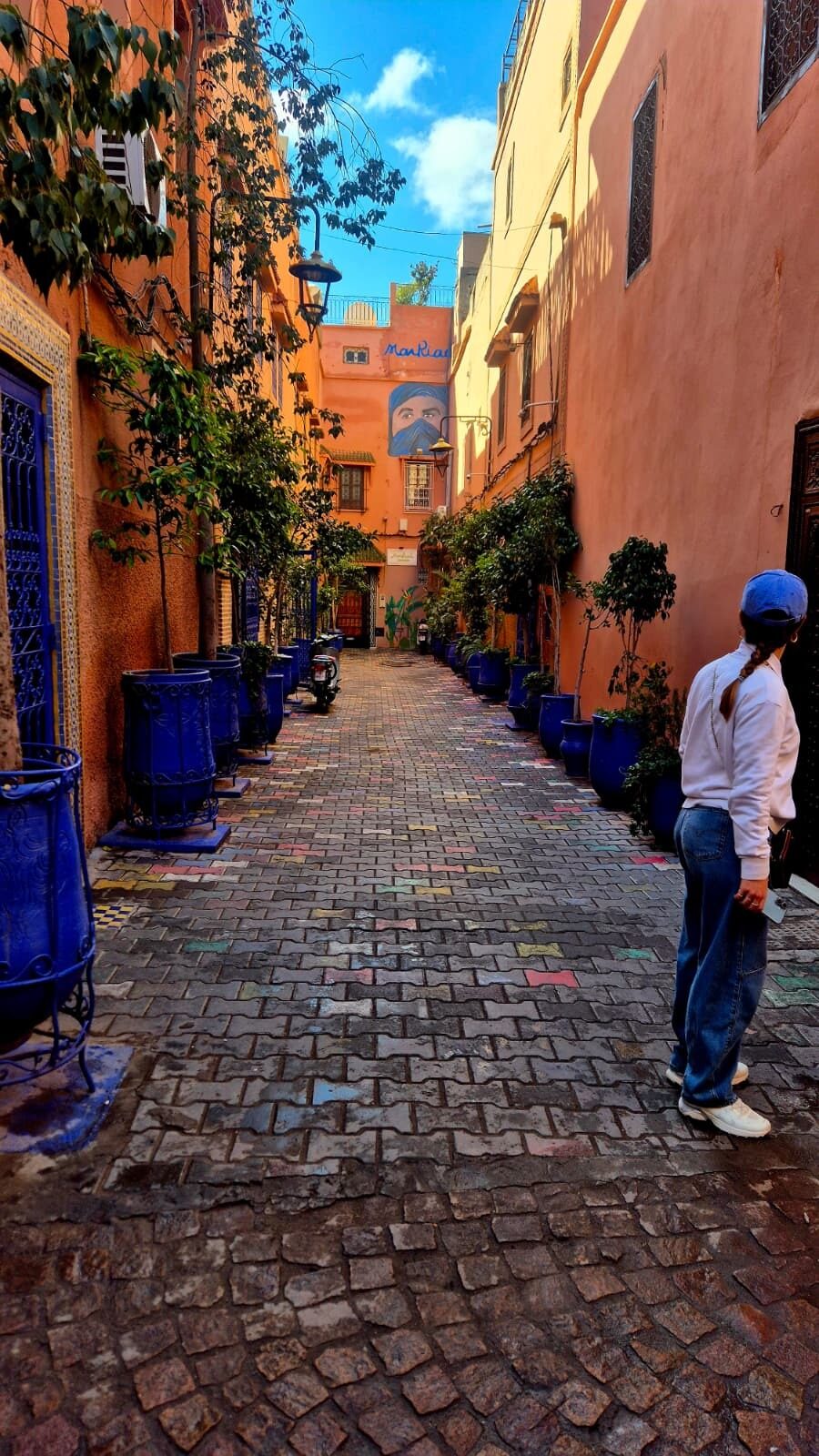 Cobbled street lined with blue pots in Marrakesh